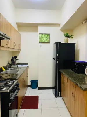 a kitchen with a black refrigerator and a stove at Hello condo in Manila