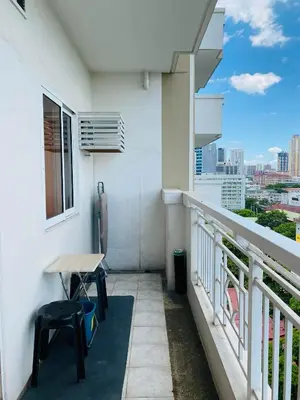 a balcony with a table and chairs on a building at Hello condo in Manila