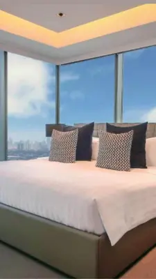 a large bed in a room with a large window at Azure Urban Paris Hilton Beach Resort in Manila