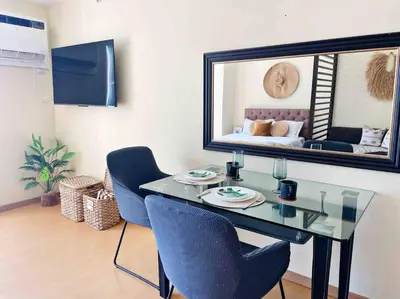a room with a table and chairs and a mirror at Jane in the City! In Avant, BGC in Manila