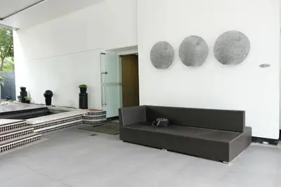 a living room with a couch on a white wall at Jane in the City! In Avant, BGC in Manila