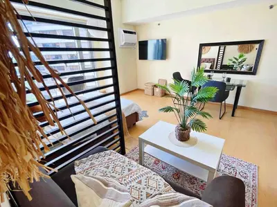 a living room with a couch and a table with a plant at Jane in the City! In Avant, BGC in Manila