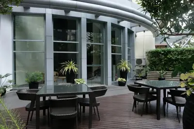 a patio with two tables and chairs in front of a building at Solana in Avant BGC parking with fee in Manila