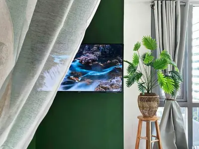 a green wall with a potted plant on a stool at Tarzan in the City! in Avant BGC parking with fee in Manila