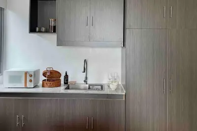 a kitchen with a sink and a microwave at Tarzan in the City! in Avant BGC parking with fee in Manila