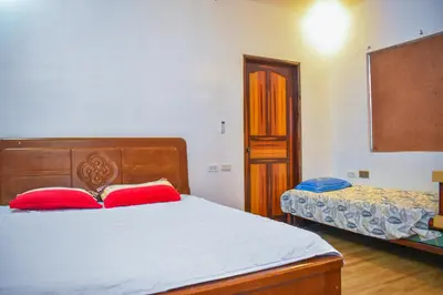 a bedroom with a bed with two red pillows at Casa de Madera The Wooden House Staycation Transient and Private Resort in Cabuyao