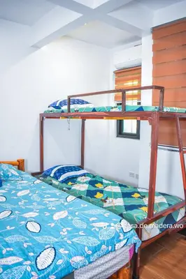 a bedroom with two bunk beds in a room at Casa de Madera The Wooden House Staycation Transient and Private Resort in Cabuyao