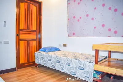 a bedroom with a small bed and a wooden table at Casa de Madera The Wooden House Staycation Transient and Private Resort in Cabuyao