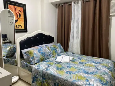 a bedroom with a bed with a blue comforter at Pierrecondotel in Manila