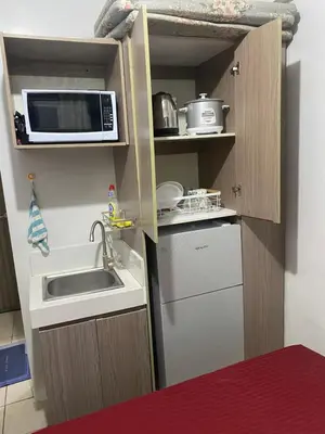 a small kitchen with a sink and a microwave at Pierrecondotel in Manila