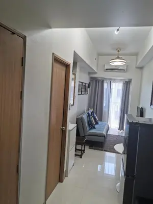 a small living room with a couch and a kitchen at Mall of Asia shore 3 residence in Manila