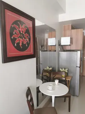 a kitchen and dining room with a table and a refrigerator at Mall of Asia shore 3 residence in Manila