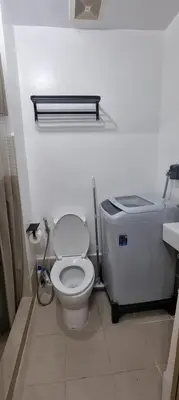 a white bathroom with a toilet and a sink at Suite 2253 in Manila