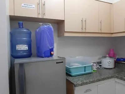 a kitchen with a bottle of water on top of a refrigerator at Sorrel Residences- 2 Bedroom Apartment in Manila