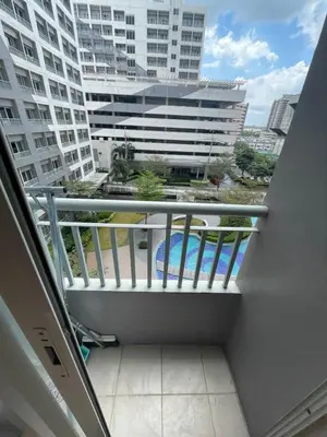 a balcony with a view of a building at Grace Residences Condo 1 BR Poolview near McKinley BGC in Manila