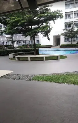 a park with a bench and a tree and a building at Grace Residences Condo 1 BR Poolview near McKinley BGC in Manila