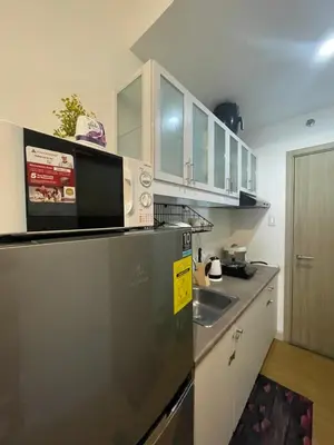 a kitchen with a stainless steel refrigerator and a sink at Grace Residences Condo 1 BR Poolview near McKinley BGC in Manila