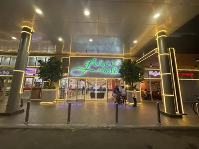 a mall with a large neon sign in front of it at Grace Residences Condo 1 BR Poolview near McKinley BGC in Manila