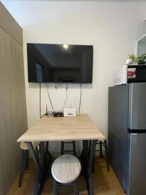 a table in a room with a tv on the wall at Grace Residences Condo 1 BR Poolview near McKinley BGC in Manila