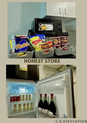 a refrigerator filled with food and drinks and a microwave at CA Staycation in Manila