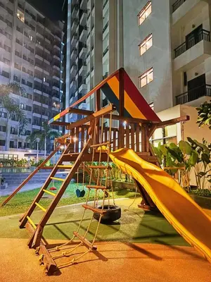 a playground with a slide in front of a building at CA Staycation in Manila