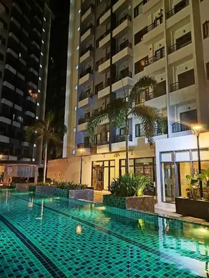 a swimming pool in front of a building at night at CA Staycation in Manila