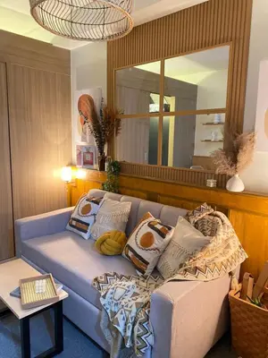 a living room with a blue couch and a mirror at Cozy Vibes near MOA & NAIA AIRPORT with NETFLIX,MINIVIDEOKE,BOARDGAMES-DUXE3 in Manila