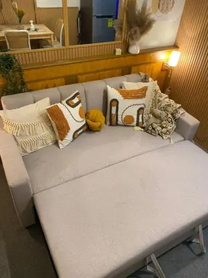 a gray couch with pillows on top of it at Cozy Vibes near MOA & NAIA AIRPORT with NETFLIX,MINIVIDEOKE,BOARDGAMES-DUXE3 in Manila