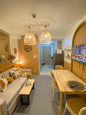 a living room with a couch and a table at Cozy Vibes near MOA & NAIA AIRPORT with NETFLIX,MINIVIDEOKE,BOARDGAMES-DUXE3 in Manila