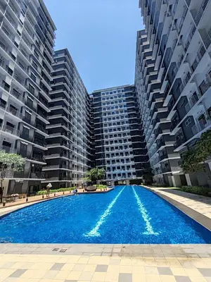 a swimming pool in front of two tall buildings at Haven of Tranquility Suite - SMDC Shore 3 (MOA) in Manila