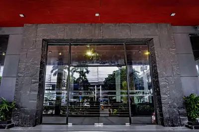 a large glass door to a building with plants at Green Sun Hotel in Manila