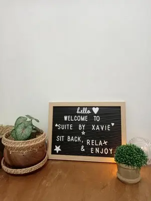 a chalkboard sign sitting on a table with a plant at Suite by Xavie The Verdin by MAPLE Grove in General Trias