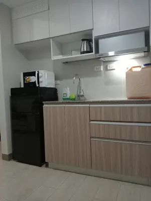 a kitchen with a sink and a black refrigerator at Suite by Xavie The Verdin by MAPLE Grove in General Trias