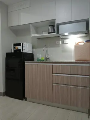 a kitchen with a sink and a refrigerator at Suite by Xavie The Verdin by MAPLE Grove in General Trias
