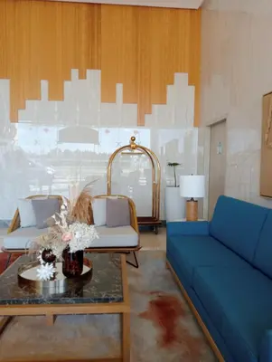 a living room with a blue couch and a table at Suite by Xavie The Verdin by MAPLE Grove in General Trias