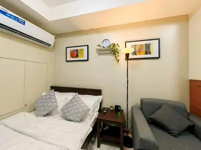 a bedroom with a bed and a chair and a table at 1BR Condotel Suite at Sunshine100 City Plaza #SS02 in Manila