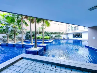a swimming pool with palm trees in a building at 1BR Condotel Suite at Sunshine100 City Plaza #SS05 in Manila