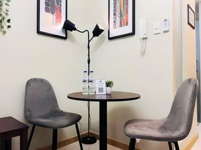 two chairs and a table with a lamp in a room at 1BR Condotel Suite at Sunshine100 City Plaza #SS05 in Manila