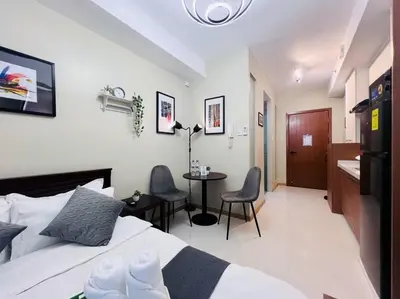 a bedroom with a bed and a table and chairs at 1BR Condotel Suite at Sunshine100 City Plaza #SS05 in Manila