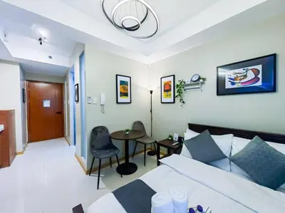 a bedroom with a bed and a table and chairs at 1BR Condotel Suite at Sunshine100 City Plaza #SS03 in Manila