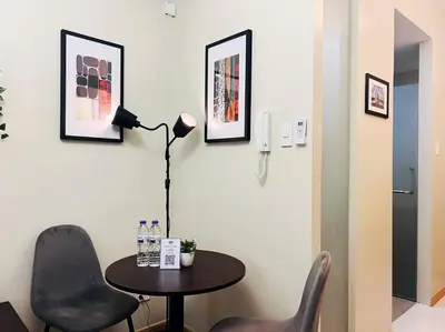 a room with a table and two chairs and a lamp at 1BR Condotel Suite at Sunshine100 City Plaza #SS04 in Manila