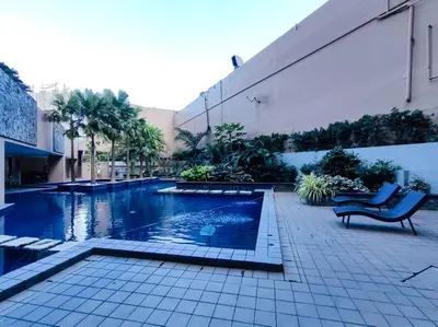 a swimming pool with a bench next to a building at 1BR Condotel Suite at Sunshine100 City Plaza #SS04 in Manila