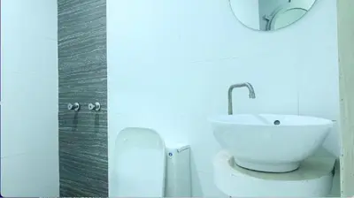 a bathroom with a white sink and a toilet at Astrotel Avenida in Manila