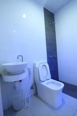 a bathroom with a white toilet and a sink at Astrotel Avenida in Manila