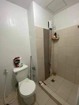a bathroom with a white toilet and a shower at Khencob's Pad Quezon City in Manila