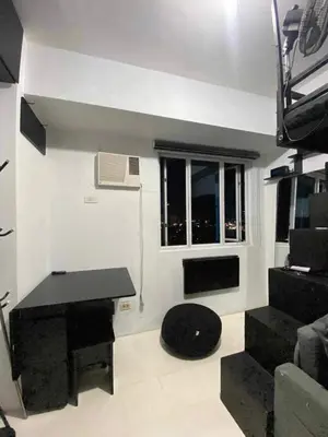 a living room with a table and a window at Khencob's Pad Quezon City in Manila