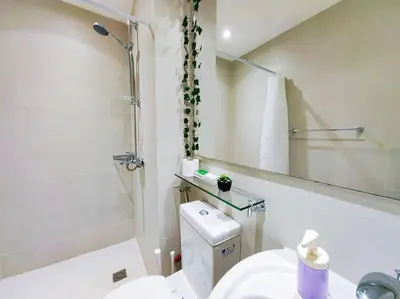 a bathroom with a toilet and a sink and a mirror at 1BR Condotel at Azure Urban Resort Near Airport #AZ03 in Manila