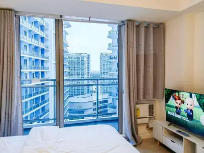 a bedroom with a large window with a view of a city at 1BR Condotel at Azure Urban Resort Near Airport #AZ03 in Manila