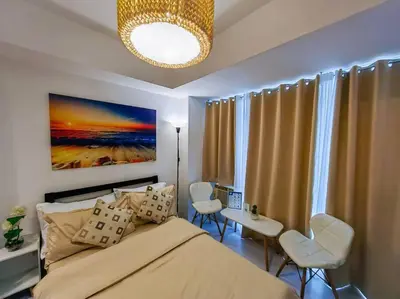 a bedroom with a bed and a table and chairs at 1BR Condotel at Azure Urban Resort Near Airport #AZ01 in Manila