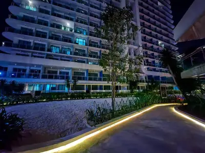 a building at night with a pool in front of it at 1BR Condotel at Azure Urban Resort Near Airport #AZ01 in Manila